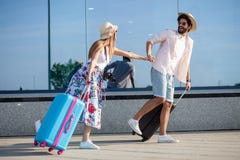 2 счастливых молодых туриста держа руки и ход перед крупным аэропортом стоковая фотография rf 2 счастливых молодых туриста держа руки и ход перед крупным аэропортом стоковая фотография rf