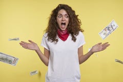 Съемка студии женщины которая выигрывает много деньги, наличных денег падая на ее голову, изолированную над желтой предпосылкой стоковое фото Съемка студии женщины которая выигрывает много деньги, наличных денег падая на ее голову, изолированную над желтой предпосылкой стоковое фото
