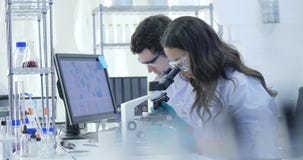Съемка тележки ученых медицинского исследования объединяется в команду работа на современной лаборатории при ученые проводя экспе видеоматериал Съемка тележки ученых медицинского исследования объединяется в команду работа на современной лаборатории при ученые проводя экспе видеоматериал