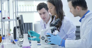 Съемка тележки ученых медицинского исследования объединяется в команду работа на современной лаборатории при ученые проводя экспе видеоматериал Съемка тележки ученых медицинского исследования объединяется в команду работа на современной лаборатории при ученые проводя экспе видеоматериал