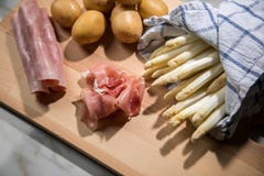 Сырцовая белая немецкая спаржа в полотенце кухни с ветчиной картошек, стоковое фото Сырцовая белая немецкая спаржа в полотенце кухни с ветчиной картошек, стоковое фото