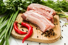 Сырцовые нервюры свинины с овощами и перцем на разделочной доске стоковое фото rf Сырцовые нервюры свинины с овощами и перцем на разделочной доске стоковое фото rf