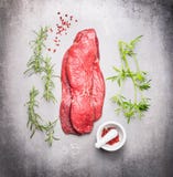 Сырцовый стейк мяса говядины с свежими травами на серой каменной предпосылке стоковая фотография rf Сырцовый стейк мяса говядины с свежими травами на серой каменной предпосылке стоковая фотография rf