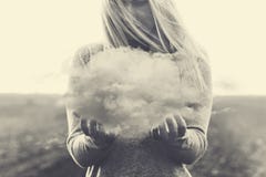 Сюрреалистический момент, солитарная женщина держа в ее руках серое облако Стоковая Фотография RF Сюрреалистический момент, солитарная женщина держа в ее руках серое облако Стоковая Фотография RF