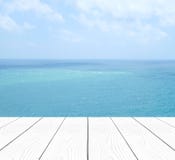 Таблица пустой перспективы белая деревянная над морем нерезкости и ба голубого неба стоковая фотография Таблица пустой перспективы белая деревянная над морем нерезкости и ба голубого неба стоковая фотография