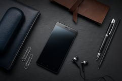 Таблица стола офиса кожаная с smartphone, наушниками и suppli стоковое фото rf Таблица стола офиса кожаная с smartphone, наушниками и suppli стоковое фото rf