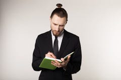 Талия вверх по съемке серьезного небритого бизнесмена в черном костюме который внимательно слушает его деловой партнера и взятия стоковая фотография rf Талия вверх по съемке серьезного небритого бизнесмена в черном костюме который внимательно слушает его деловой партнера и взятия стоковая фотография rf