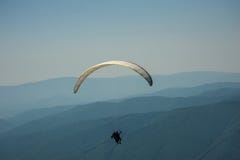 Тандем параглайдинга летает над долиной горы на солнечной сумме стоковое фото Тандем параглайдинга летает над долиной горы на солнечной сумме стоковое фото