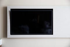 ТВ на белой стене стоковые фотографии rf ТВ на белой стене стоковые фотографии rf