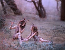 Творческая фантастическая стрельба семьи, мама faun играет колыбельную на каннелюре для ее ребенка, олене характеров сказки внутр стоковые фотографии rf Творческая фантастическая стрельба семьи, мама faun играет колыбельную на каннелюре для ее ребенка, олене характеров сказки внутр стоковые фотографии rf