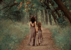 Творческое семейное фото матери брюнета и белокурой дочери, fauns держит руки и пройдет в глубь лес вдоль стоковые изображения Творческое семейное фото матери брюнета и белокурой дочери, fauns держит руки и пройдет в глубь лес вдоль стоковые изображения