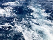 Текстура бурля голубой соленой воды моря с волнами, расслоины, пузыри, пена, трассировки, разрывает после быстрой плавая тележки, стоковое изображение Текстура бурля голубой соленой воды моря с волнами, расслоины, пузыри, пена, трассировки, разрывает после быстрой плавая тележки, стоковое изображение