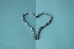 Текстура красивой золотой дорогой праздничной цепи уникальный соткать в форме сердца на голубом космосе предпосылки и экземпляра стоковое фото Текстура красивой золотой дорогой праздничной цепи уникальный соткать в форме сердца на голубом космосе предпосылки и экземпляра стоковое фото