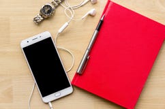 Тетрадь пробела крышки Красной книги с ручкой на деревянной таблице и чае телефона шлемофона наручных часов современном Стоковое Изображение RF Тетрадь пробела крышки Красной книги с ручкой на деревянной таблице и чае телефона шлемофона наручных часов современном Стоковое Изображение RF