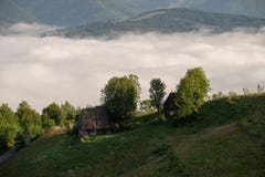 Традиционные дома в Трансильвании, восход солнца с туманом в горах, Румынией стоковые изображения rf Традиционные дома в Трансильвании, восход солнца с туманом в горах, Румынией стоковые изображения rf