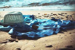 Туника шляпы и пляжа на пляже с морем на заднем плане стоковое изображение Туника шляпы и пляжа на пляже с морем на заднем плане стоковое изображение