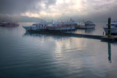 Туристские шлюпки паркуя на мирной воде и причаленные к плавучим докам пристани Shuishe на озере Солнц-лун стоковое изображение rf Туристские шлюпки паркуя на мирной воде и причаленные к плавучим докам пристани Shuishe на озере Солнц-лун стоковое изображение rf