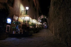 Туристский имейте обедающий в улице вечером В территории della Pescaia Castiglione стоковое фото rf Туристский имейте обедающий в улице вечером В территории della Pescaia Castiglione стоковое фото rf