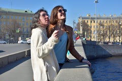 Туристы молодых дам в стойке Санкт-Петербурга России на мосте на желтые здания придают квадратную форму и наблюдают архитектурноа стоковое изображение Туристы молодых дам в стойке Санкт-Петербурга России на мосте на желтые здания придают квадратную форму и наблюдают архитектурноа стоковое изображение