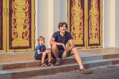 Туристы отца и сына в тайском виске в городке Wat Mongkolnimit Пхукета стоковое изображение rf Туристы отца и сына в тайском виске в городке Wat Mongkolnimit Пхукета стоковое изображение rf