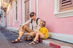 Туристы папы и сына на улице в португальском стиле Romani в городке Пхукета Также вызвал Чайна-таун или старый городок стоковое фото rf Туристы папы и сына на улице в португальском стиле Romani в городке Пхукета Также вызвал Чайна-таун или старый городок стоковое фото rf