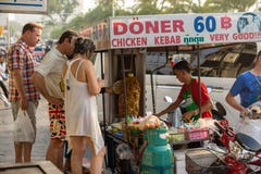 Туристы стоят на мобильном стойле и покупают kebabs стоковые изображения Туристы стоят на мобильном стойле и покупают kebabs стоковые изображения