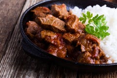 Тушеное мясо говядины, который служат с белым рисом в skillet литого железа стоковая фотография rf Тушеное мясо говядины, который служат с белым рисом в skillet литого железа стоковая фотография rf