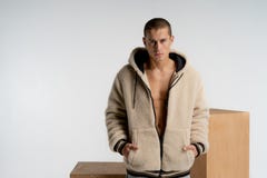 Уверенный серьезный красивый человек с короткой стрижкой, нося стильный sportswear, смотрящ камеру, держа руки внутри стоковое фото rf Уверенный серьезный красивый человек с короткой стрижкой, нося стильный sportswear, смотрящ камеру, держа руки внутри стоковое фото rf