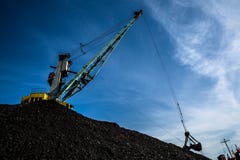 Уголь крана гавани нагружая против голубого неба и облаков стоковые изображения Уголь крана гавани нагружая против голубого неба и облаков стоковые изображения