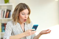 Удивленная девушка наблюдая онлайн содержание в голубом телефоне стоковые изображения Удивленная девушка наблюдая онлайн содержание в голубом телефоне стоковые изображения