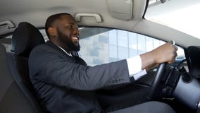 Удовлетворенный человек в деловом костюме сидя в автомобиле, успешном приобретении, счастье стоковая фотография Удовлетворенный человек в деловом костюме сидя в автомобиле, успешном приобретении, счастье стоковая фотография