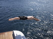 Укомплектуйте личным составом подныривание в море от яхты стоковые фотографии rf Укомплектуйте личным составом подныривание в море от яхты стоковые фотографии rf