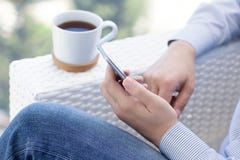 Укомплектуйте личным составом сидеть в чае кафа лета выпивая и держать телефон стоковые изображения rf Укомплектуйте личным составом сидеть в чае кафа лета выпивая и держать телефон стоковые изображения rf