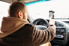 Укомплектуйте личным составом водителя в автомобиле касаясь вручную экрану smartphone с системой навигации применения стоковые изображения Укомплектуйте личным составом водителя в автомобиле касаясь вручную экрану smartphone с системой навигации применения стоковые изображения