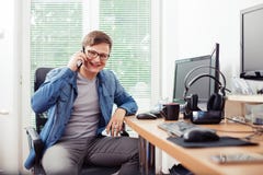 Укомплектуйте личным составом говорить на мобильном телефоне в офисе стоковые изображения Укомплектуйте личным составом говорить на мобильном телефоне в офисе стоковые изображения