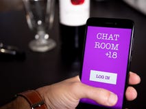 Укомплектуйте личным составом держать телефон с болтовней app в ресторане стоковое фото rf Укомплектуйте личным составом держать телефон с болтовней app в ресторане стоковое фото rf
