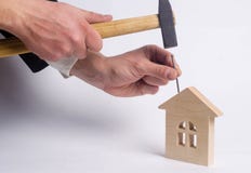 Укомплектуйте личным составом молотки ноготь с молотком в миниатюрном деревянном доме дальше стоковое фото rf Укомплектуйте личным составом молотки ноготь с молотком в миниатюрном деревянном доме дальше стоковое фото rf