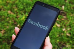 Украина, Kremenchug - апрель 2019: Девушка со смартфоном в ее руке и логотип Facebook на экране изображение сети 3d представило s стоковое изображение Украина, Kremenchug - апрель 2019: Девушка со смартфоном в ее руке и логотип Facebook на экране изображение сети 3d представило s стоковое изображение
