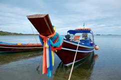 Украшенная тайская традиционная рыбацкая лодка на тропическом пляже стоковое фото rf Украшенная тайская традиционная рыбацкая лодка на тропическом пляже стоковое фото rf