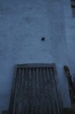 Улитка бродяжничая на стене дома над деревянным стулом стоковые изображения rf Улитка бродяжничая на стене дома над деревянным стулом стоковые изображения rf
