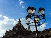 Уличный фонарь, собор, небо и облака на заходе солнца стоковые изображения Уличный фонарь, собор, небо и облака на заходе солнца стоковые изображения