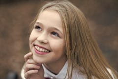 Улыбка с милой стороной, красота девушки Маленький ребенок усмехаясь с длинными светлыми волосами, стилем причёсок внешним Красот стоковая фотография rf Улыбка с милой стороной, красота девушки Маленький ребенок усмехаясь с длинными светлыми волосами, стилем причёсок внешним Красот стоковая фотография rf