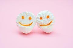 2 улыбки зефира в eggshell стоят в объятии друг с другом на розовой предпосылке стоковые изображения rf 2 улыбки зефира в eggshell стоят в объятии друг с другом на розовой предпосылке стоковые изображения rf