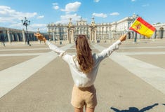 Ультрамодная женщина с ликованием флага Испании против королевского дворца стоковое изображение rf Ультрамодная женщина с ликованием флага Испании против королевского дворца стоковое изображение rf