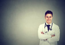 Усмехаясь доктор представляя при пересеченные оружия стоковые изображения Усмехаясь доктор представляя при пересеченные оружия стоковые изображения