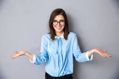 Усмехаясь коммерсантка в жесте спрашивать над серой предпосылкой стоковое изображение rf Усмехаясь коммерсантка в жесте спрашивать над серой предпосылкой стоковое изображение rf