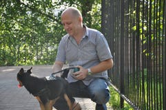 Усмехаясь облыселый человек с собакой стоковая фотография Усмехаясь облыселый человек с собакой стоковая фотография