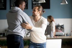 Усмехаясь разнообразные мужские друзья обнимая приветствие на встрече в ca стоковое изображение rf Усмехаясь разнообразные мужские друзья обнимая приветствие на встрече в ca стоковое изображение rf