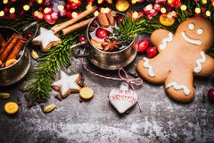 Усмехаясь люди пряника с кружкой обдумыванных вина, украшения рождества и печений и специй праздника на темных деревенских wi пре Стоковое Изображение RF Усмехаясь люди пряника с кружкой обдумыванных вина, украшения рождества и печений и специй праздника на темных деревенских wi пре Стоковое Изображение RF