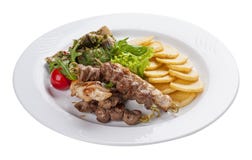 Установите kebabs с гарниром овоща на белой плите стоковое фото Установите kebabs с гарниром овоща на белой плите стоковое фото